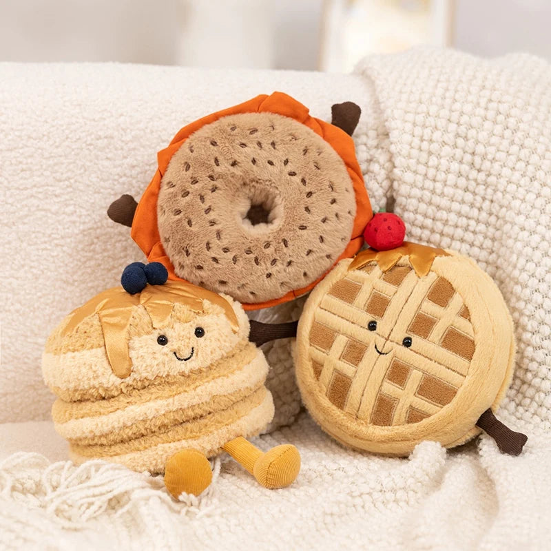 Plush kawaii toys shaped like a bagel, cookie, and pie on a soft surface.