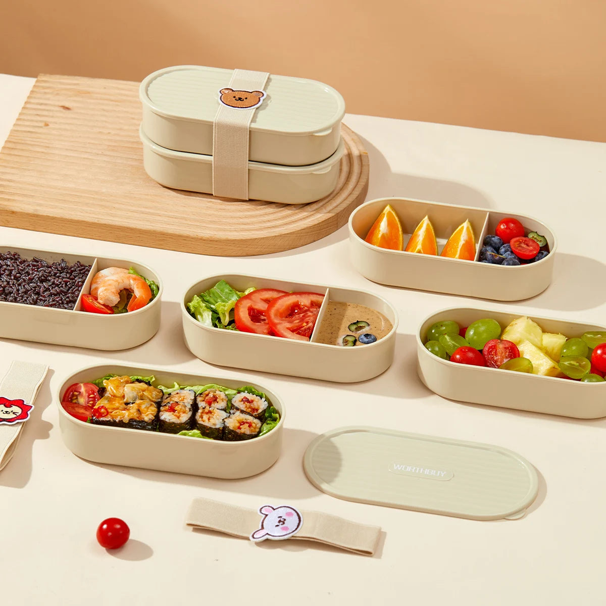 Set of kawaii bento boxes with compartments filled with food on a beige surface.
