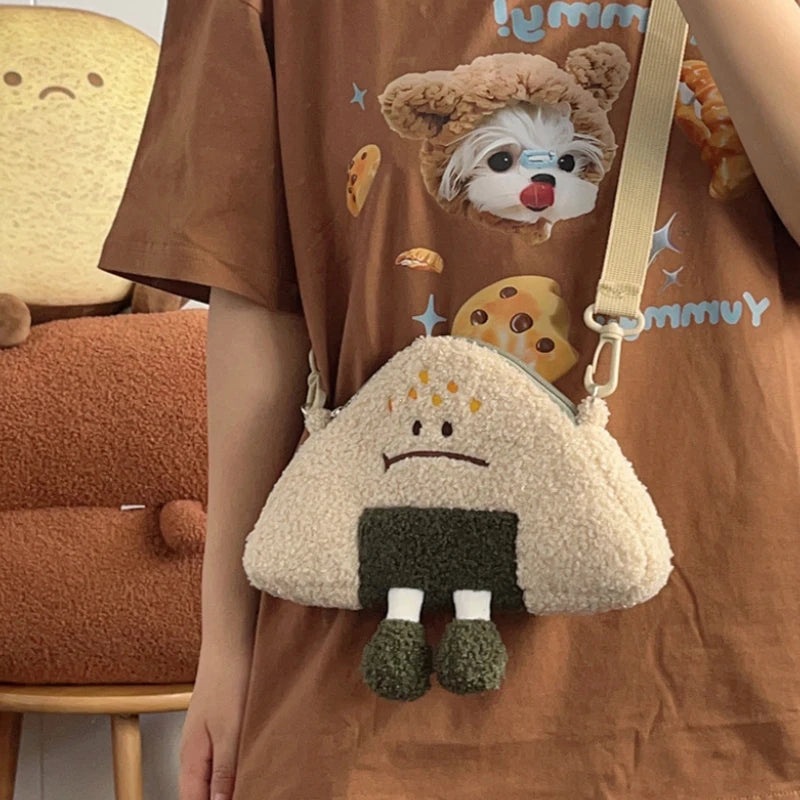 Person wearing a brown shirt with a Kawaii cartoon character and holding a fluffy white bag with a small figure on it.