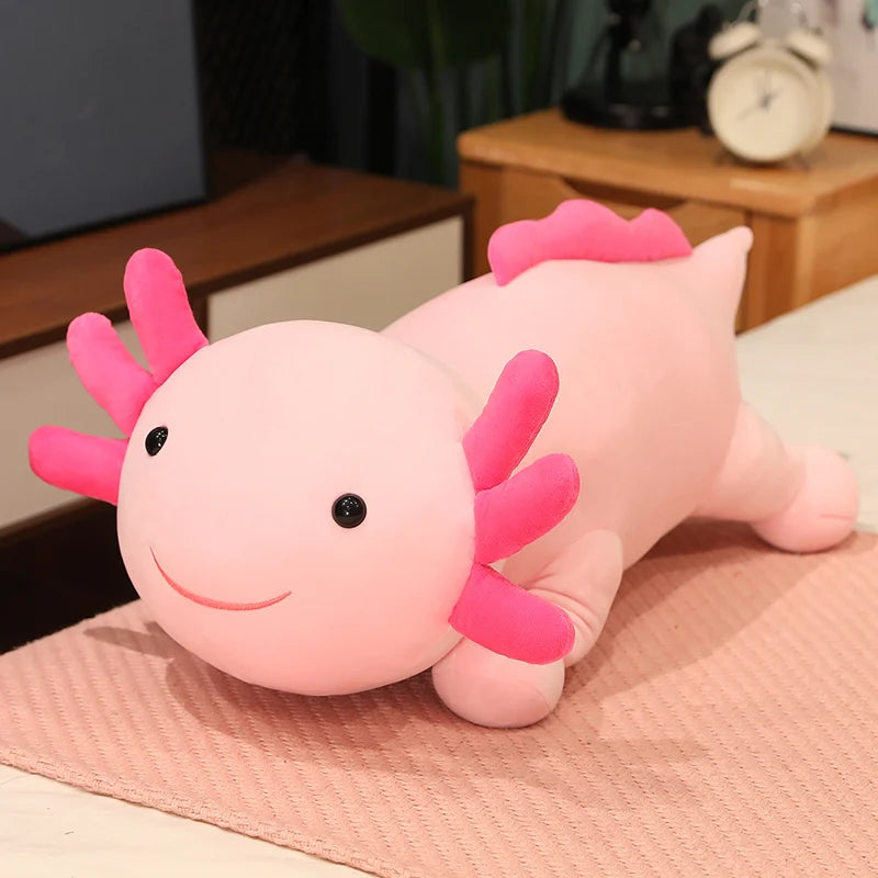 Pink axolotl plush kawaii toy on a textured surface with a blurred background
