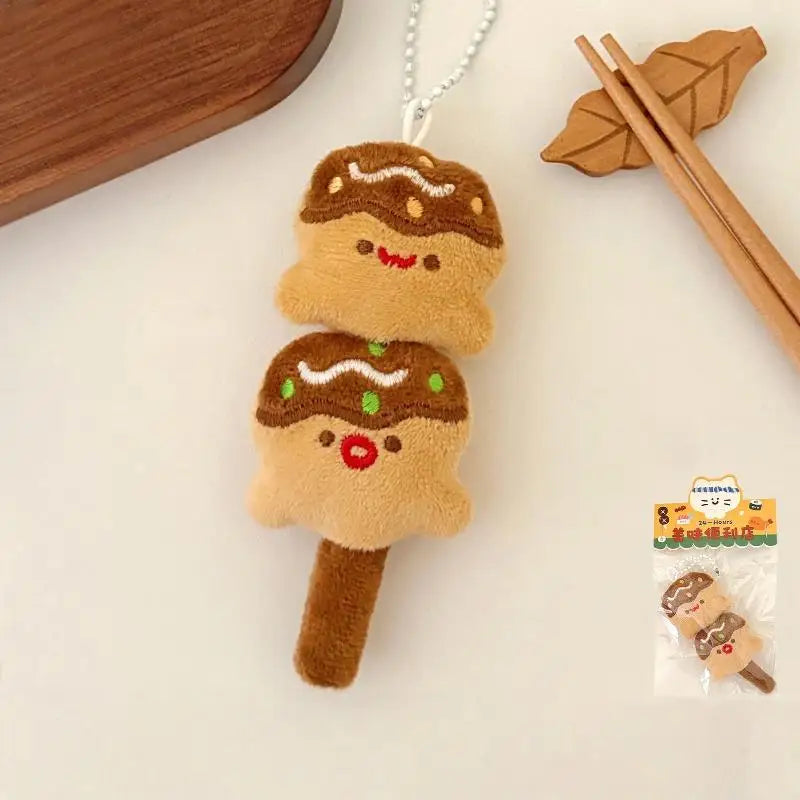 Plush toy resembling a kawaii gingerbread man on a stick with a small packaging labeled 'Gingerbread Man' in the corner.