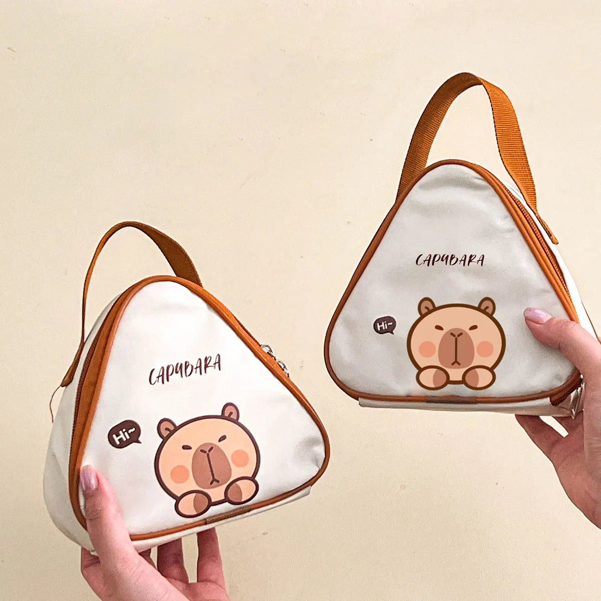 Two triangular bags with kawaii cartoon bear design and 'Camibara' branding on a beige background.