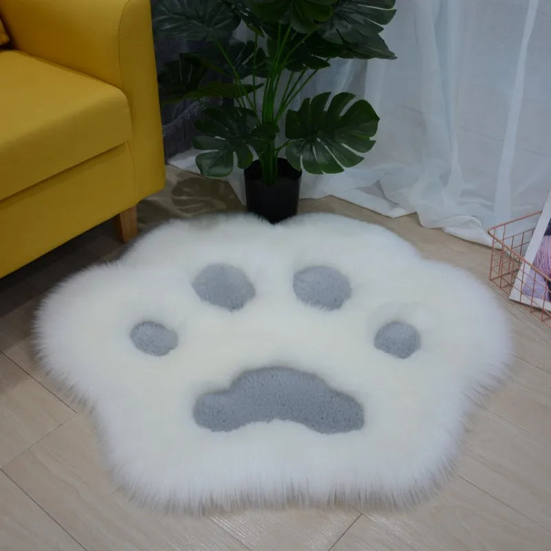 Round fluffy kawaii rug with a paw print design in a room with a yellow couch and plant.