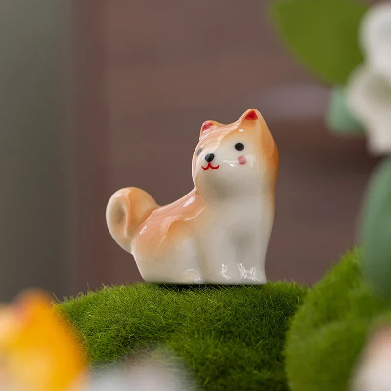 Small ceramic kawaii dog figurine on a bed of green moss with a blurred background