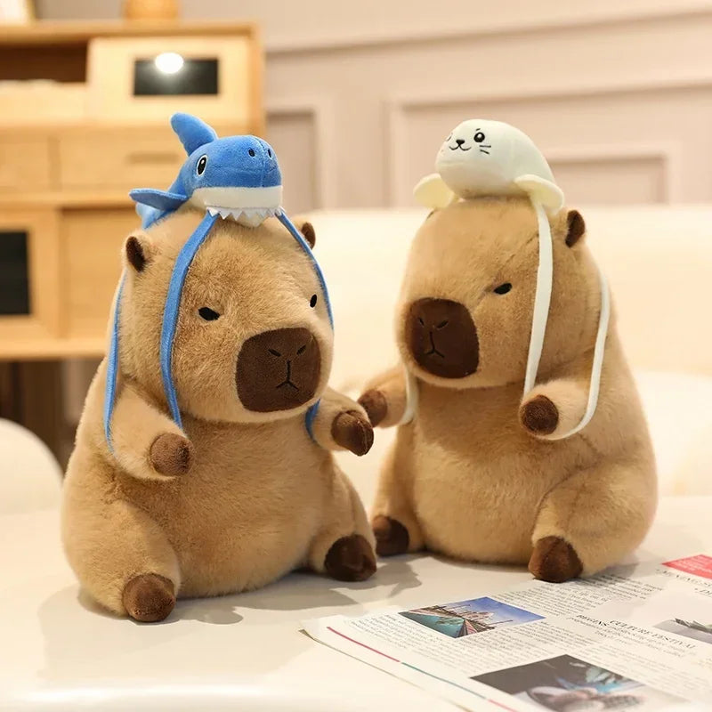 Two kawaii plush toys resembling beavers with animal hats on a surface.