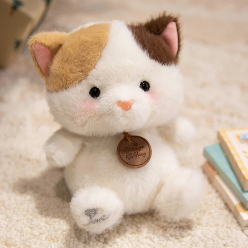 Plush cat kawaii toy with a brown tag on a soft surface