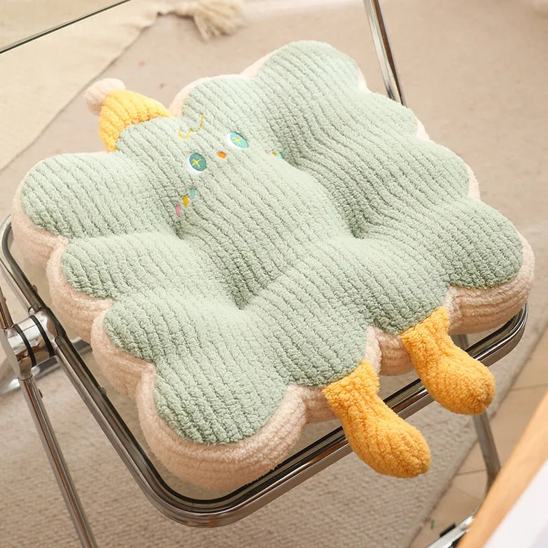 A green and yellow kawaii cushion on a chair