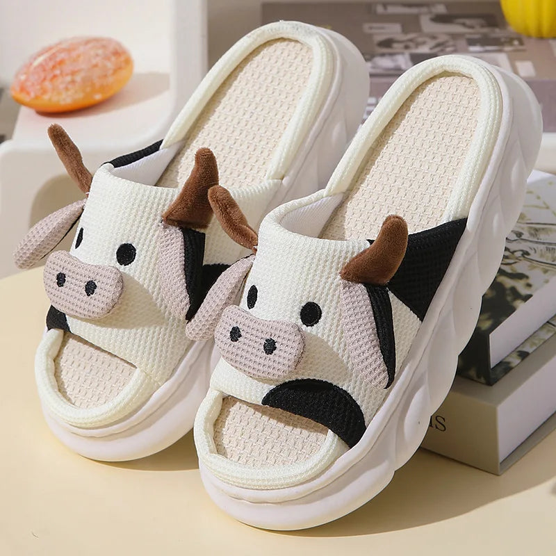 Cow-themed kawaii slippers on a light surface with a blurred background