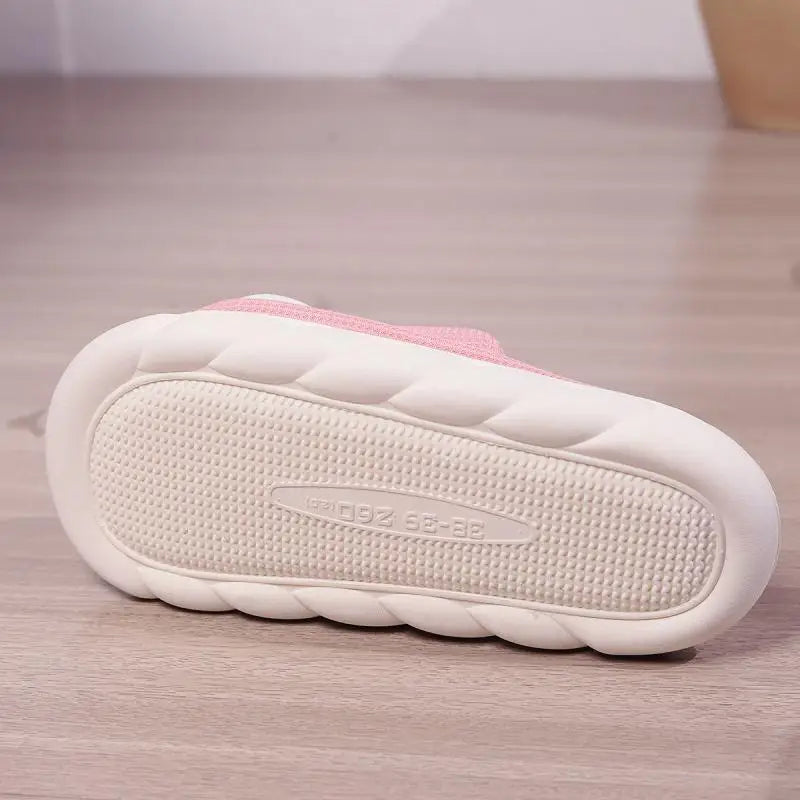 White kawaii slipper with pink top on a wooden floor