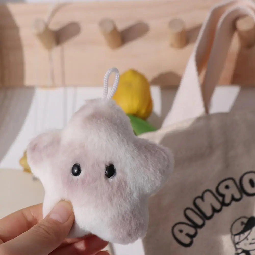 White kawaii plush toy held by a hand with a blurred background