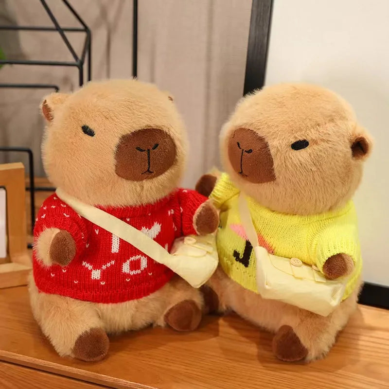 Two kawaii plush toys resembling bears wearing red and yellow sweaters on a wooden surface.