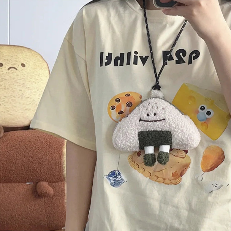 Person wearing a white t-shirt with cartoon character designs and a Kawaii plush toy pendant.