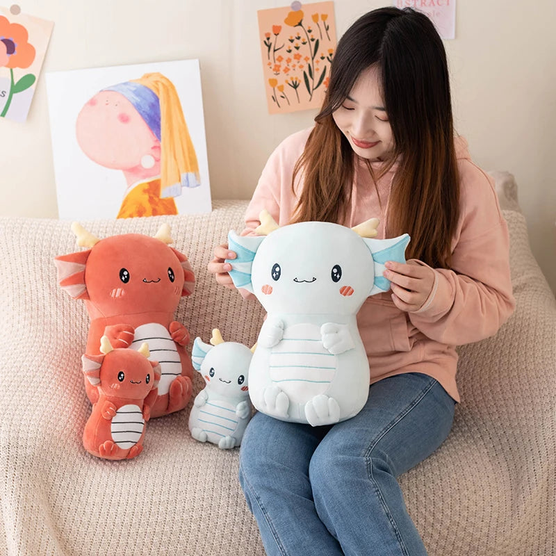 Woman holding a white kawaii  plush toy with a cat-like design, surrounded by other plush toys on a couch.