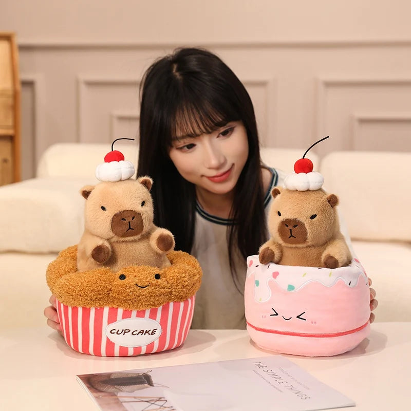 Two kawaii plush toys resembling bears in cupcake containers with a person sitting behind them.