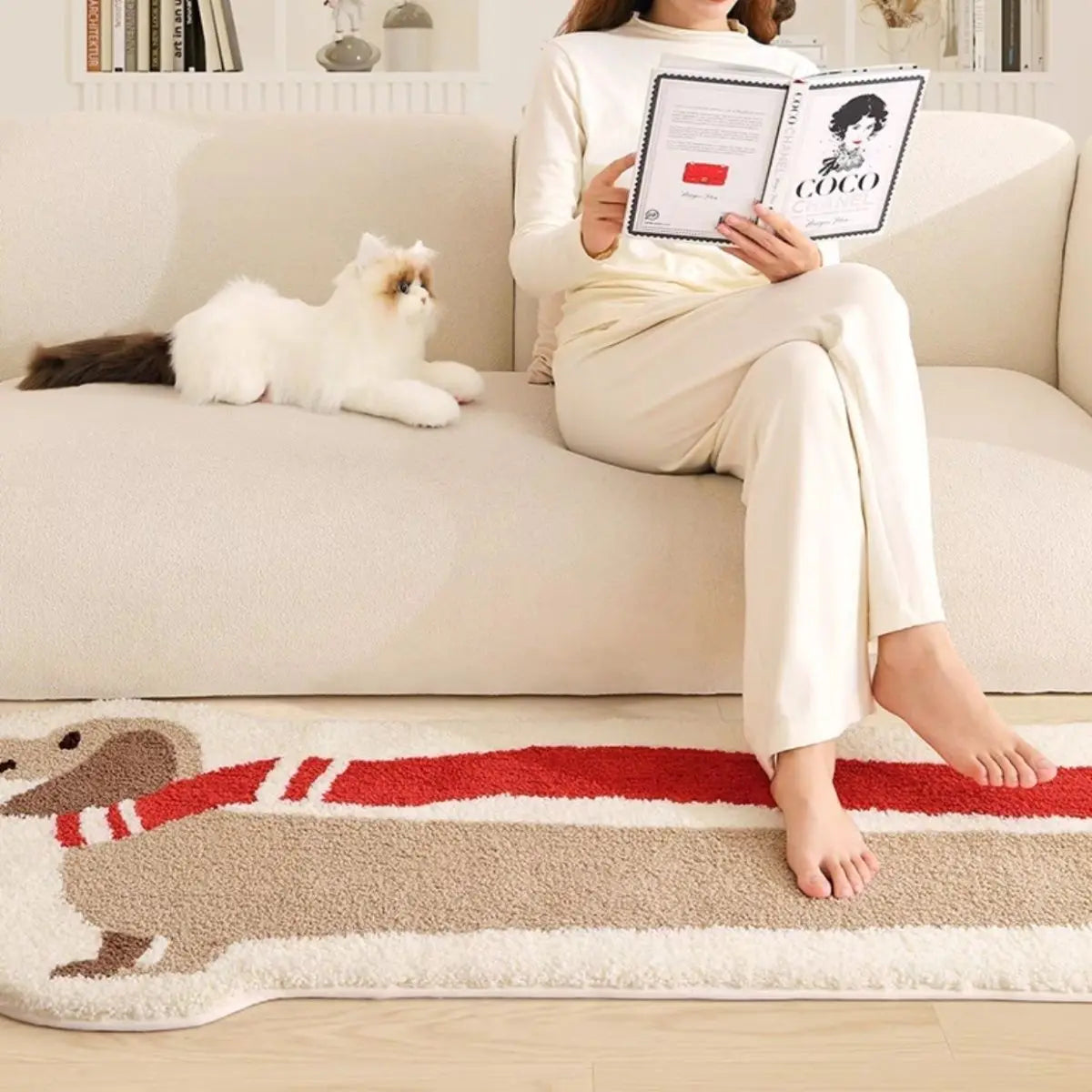Person sitting on a couch with a cat, reading a book, and a dog-themed kawaii rug in the foreground.