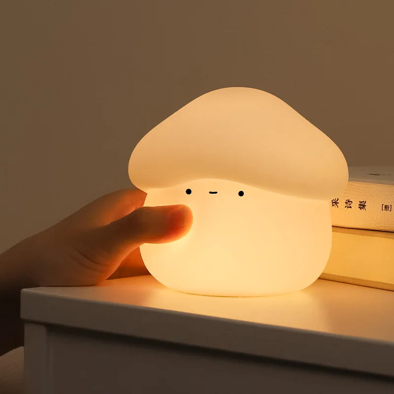 Cute mushroom-shaped kawaii night light being held by a hand on a wooden surface.