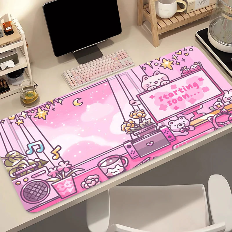 Kawaii pink cartoon-themed mouse pad on a desk with computer equipment.