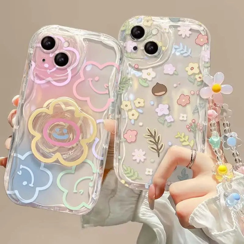 Two transparent phone cases with kawaii floral designs held by a person.