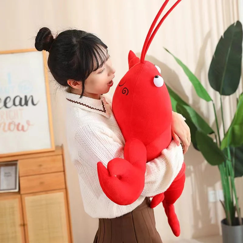 Person holding a large red kawaii plush lobster toy indoors.