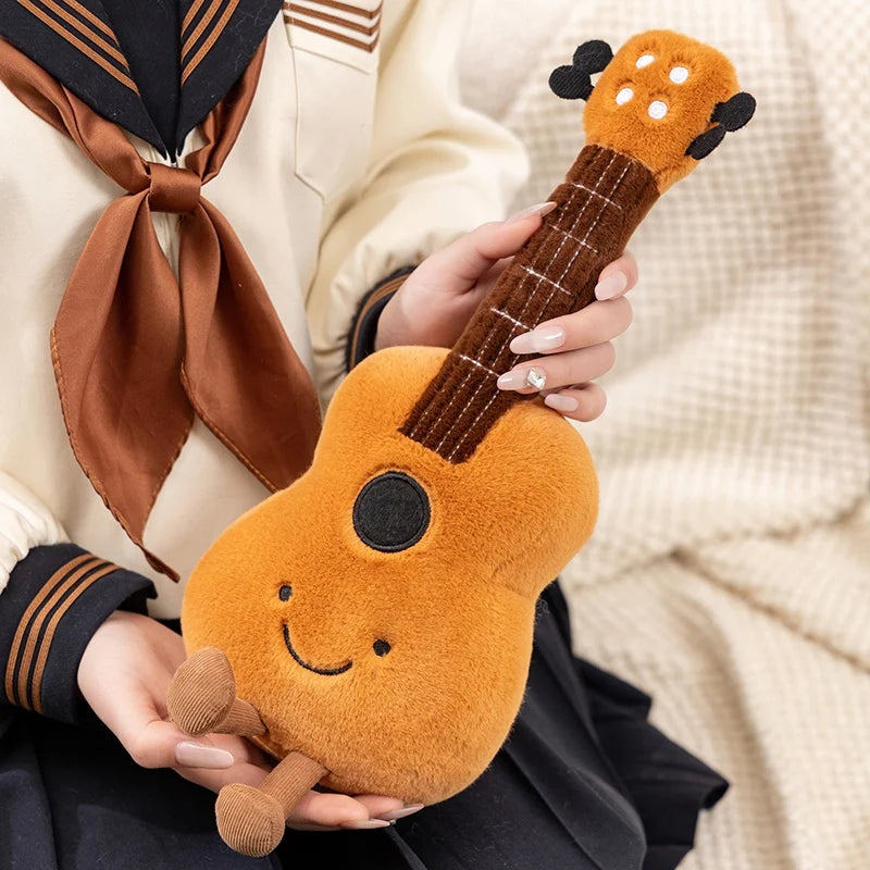 Person holding a plush kawaii toy guitar with a smiley face on a neutral background
