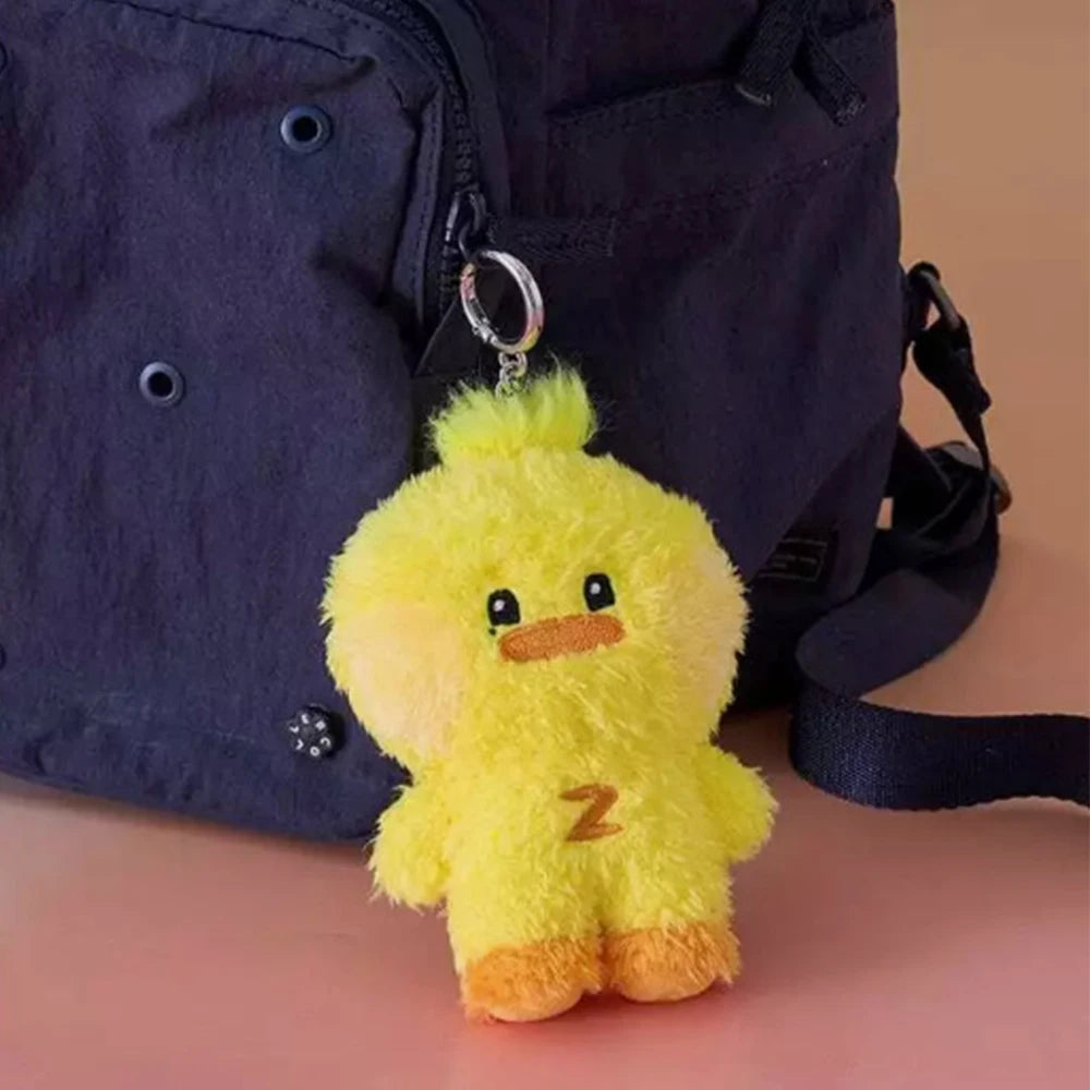 Yellow kawaii plush duck keychain with a letter 'Z' on a dark blue backpack.