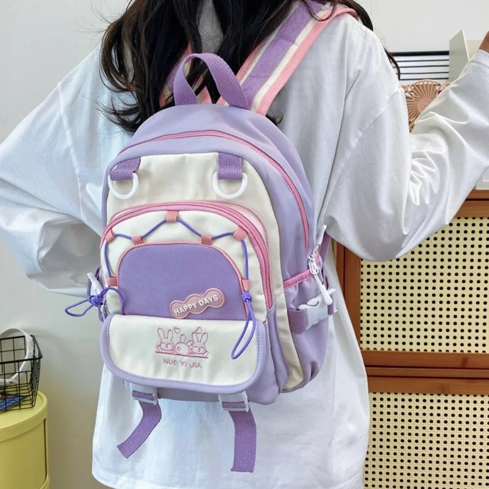 Person wearing a Kawaii pastel-colored backpack with pink and purple accents.