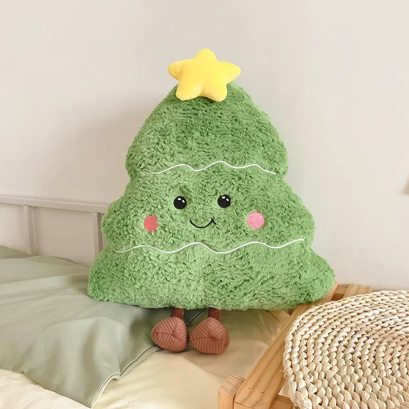 Green kawaii plush toy shaped like a tree with a star on top, sitting on a bed.