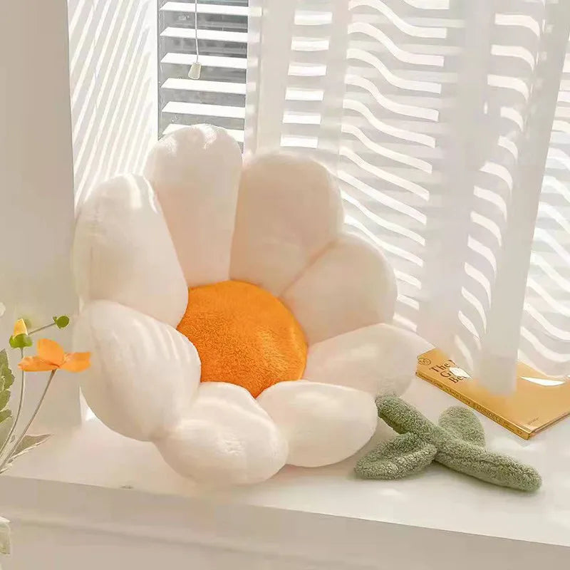 Kawaii plush toy shaped like a flower with white petals and an orange center on a light surface.