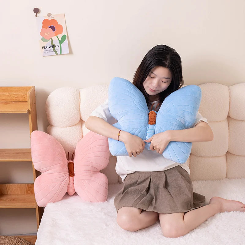 Woman holding a blue butterfly-shaped kawaii pillow in a cozy room.