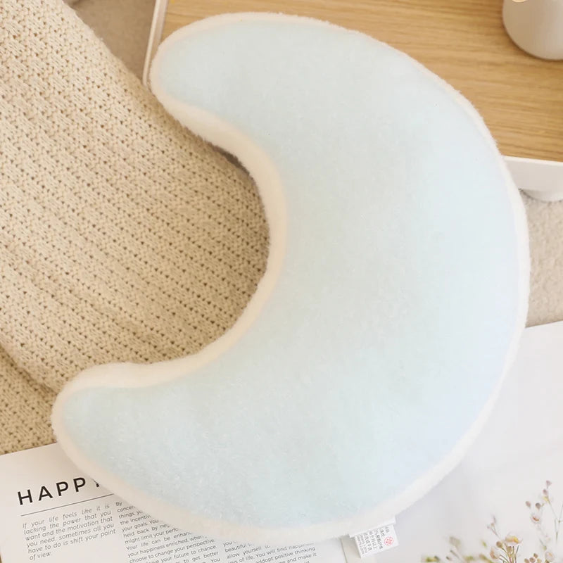 Light blue U-shaped kawaii pillow on a wooden surface with a magazine underneath