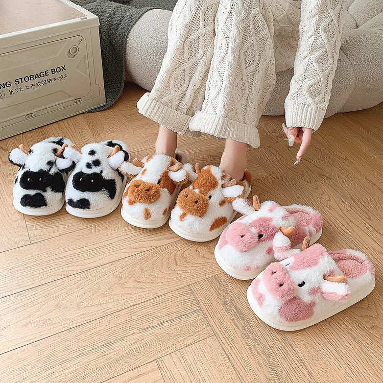 Four pairs of kawaii cow-themed slippers on a wooden floor with a person wearing one of the pairs.