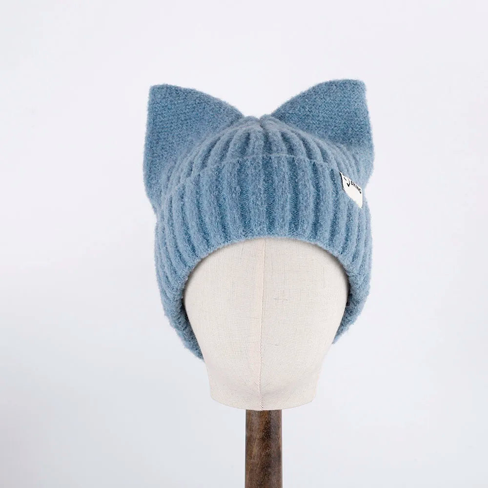 Blue knitted cat ear Kawaii hat on a mannequin head against a white background