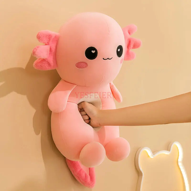 Pink kawaii plush toy with black eyes and pink bows held by a hand against a beige background