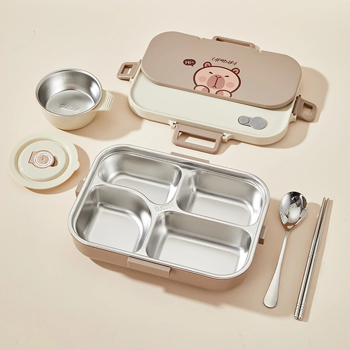 Kawaii-style lunch box set with compartments, bowl, spoon, and chopsticks on a beige background