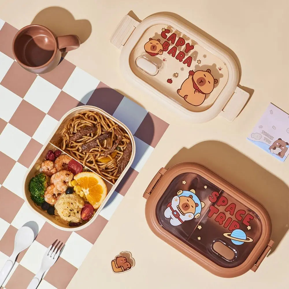 Two kawaii cartoon-themed bento boxes with food on a checkered tablecloth.