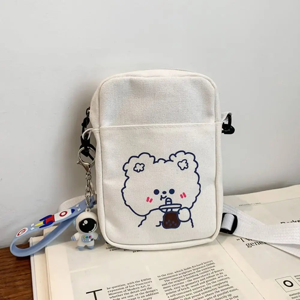 White pouch with Kawaii cartoon character and keychain on an open book