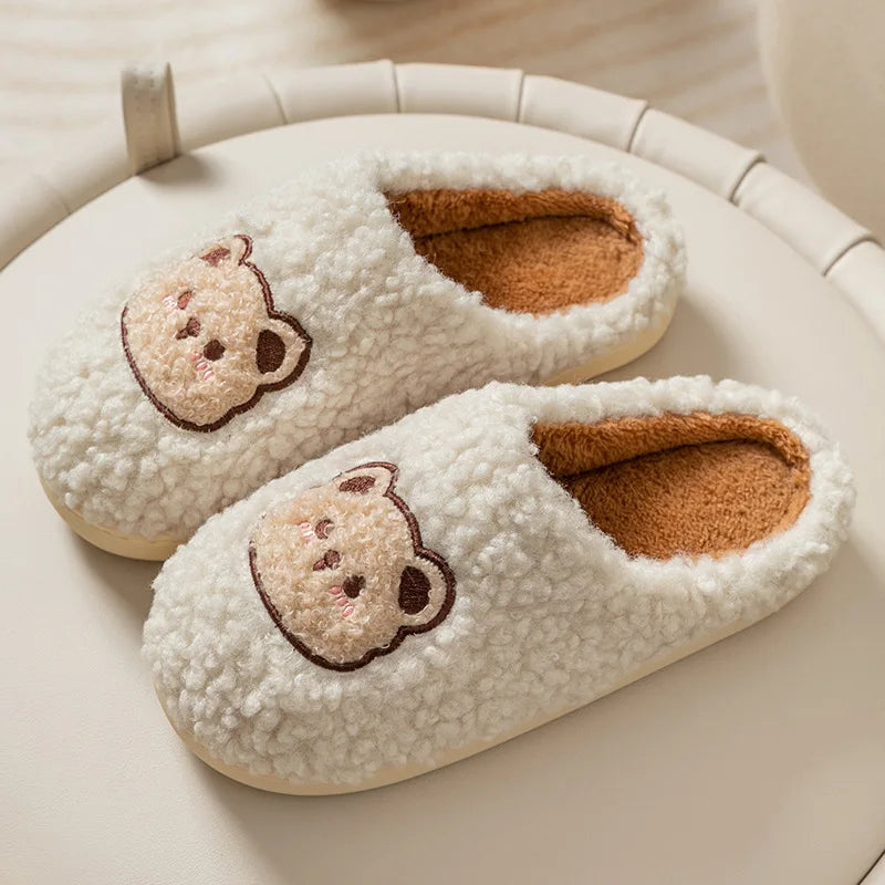 Pair of white slippers with kawaii bear face design on a light background