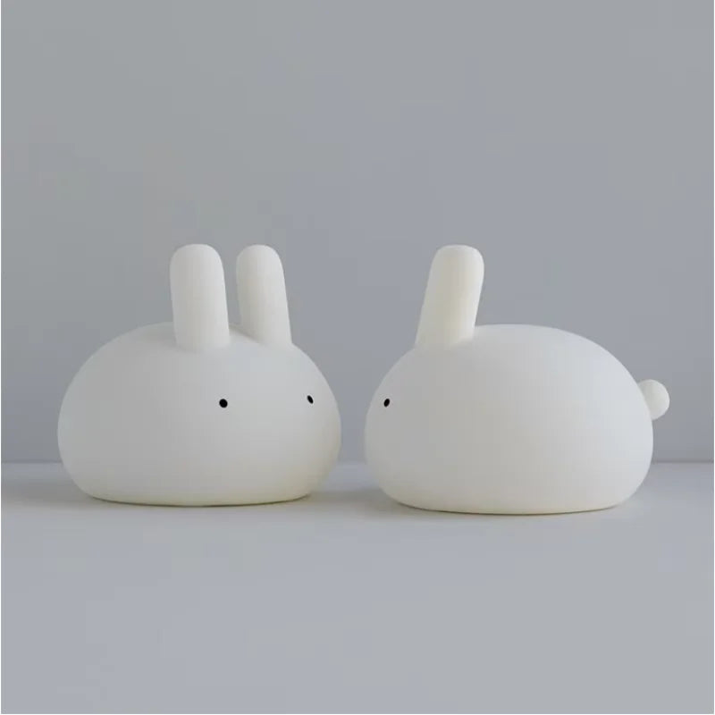 Two white rabbit-shaped kawaii night lights on a light gray surface with a light gray background