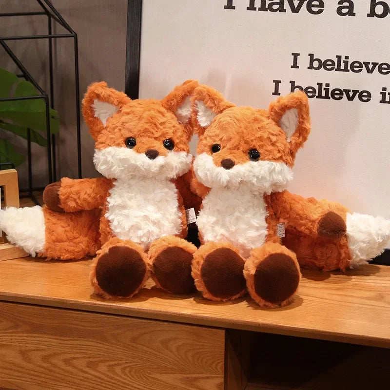 Two plush fox kawaii toys on a wooden surface with a blurred background.