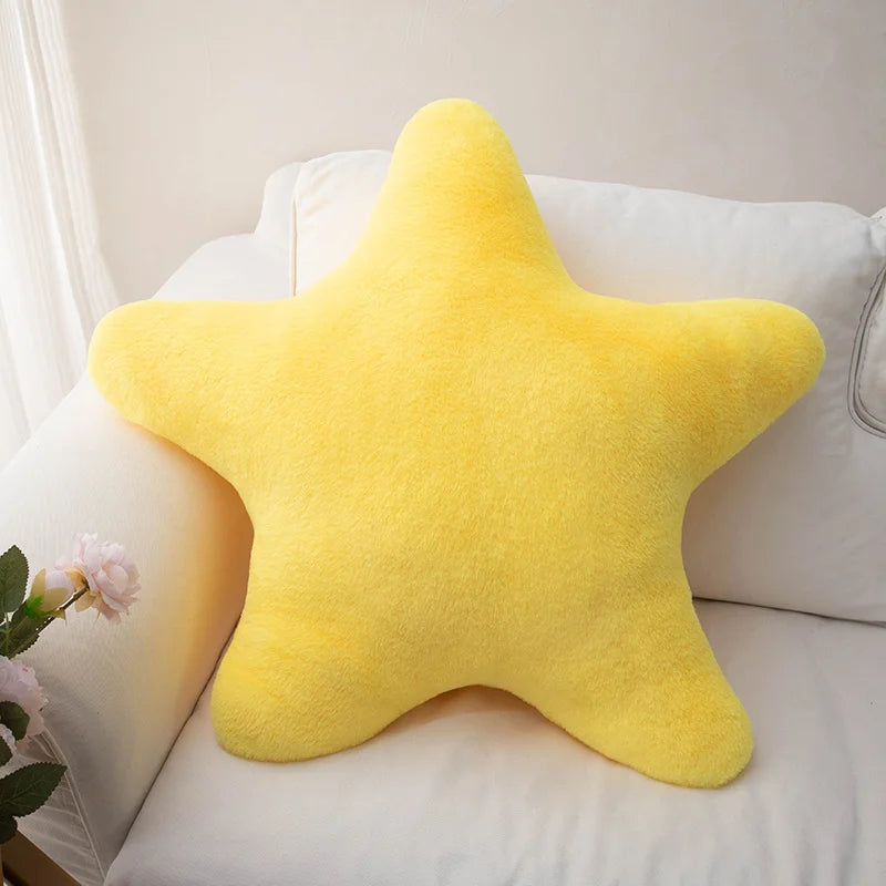 Yellow star-shaped kawaii pillow on a white couch with a light background