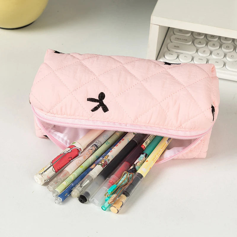 Pink kawaii pencil case with pens on a light surface