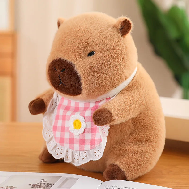 Kawaii plush toy bear wearing a pink checkered dress with a flower on a wooden surface.