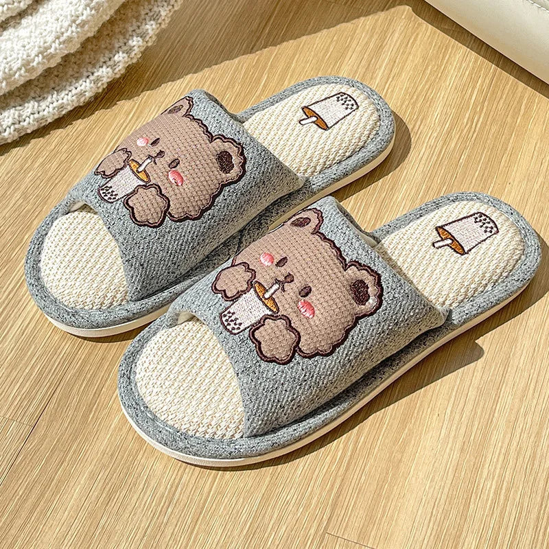 Pair of cartoon kawaii bear slippers on a wooden floor