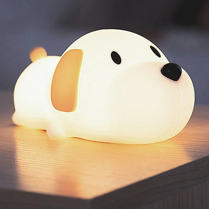 Dog-shaped kawaii night light on a wooden surface with a dark background