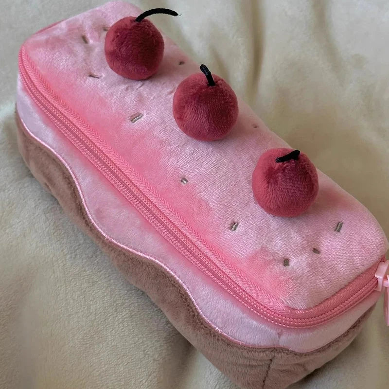 Pink pencil case with kawaii cherry decorations on a light background