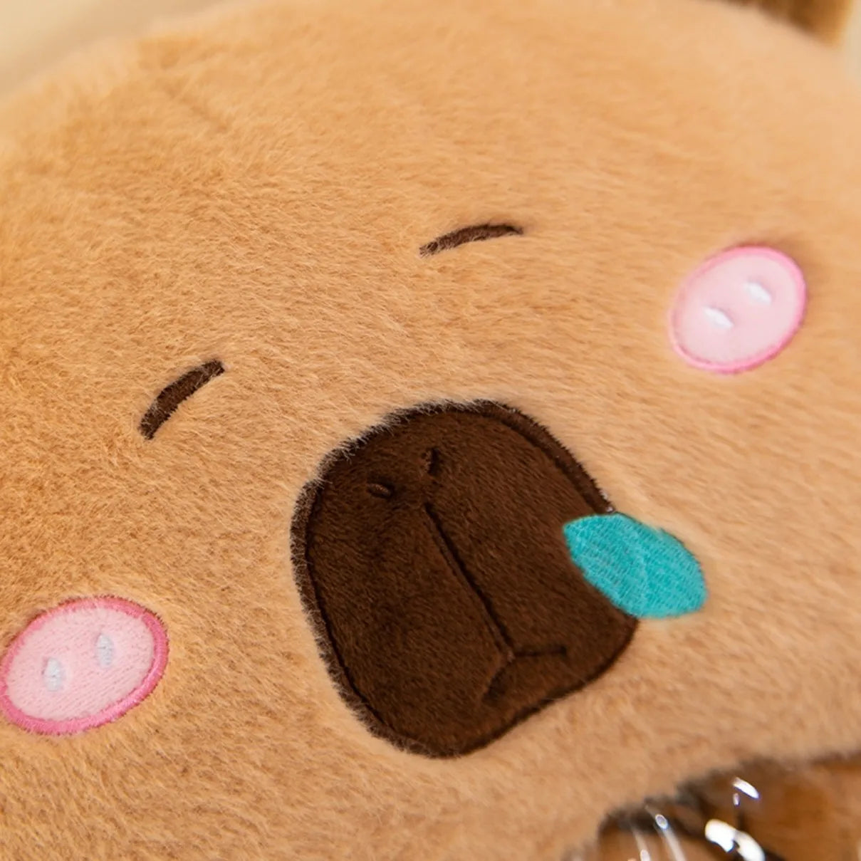 Close-up of a kawaii plush toy with a sad expression on a beige background