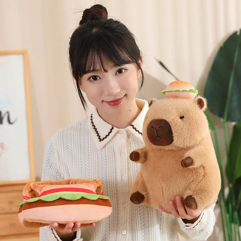 Person holding a kawaii plush toy shaped like a bear with a hamburger on its head and a hamburger-shaped pillow.