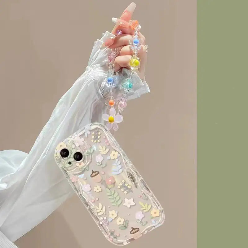 Decorative phone case with floral kawaii design held by a hand against a neutral background