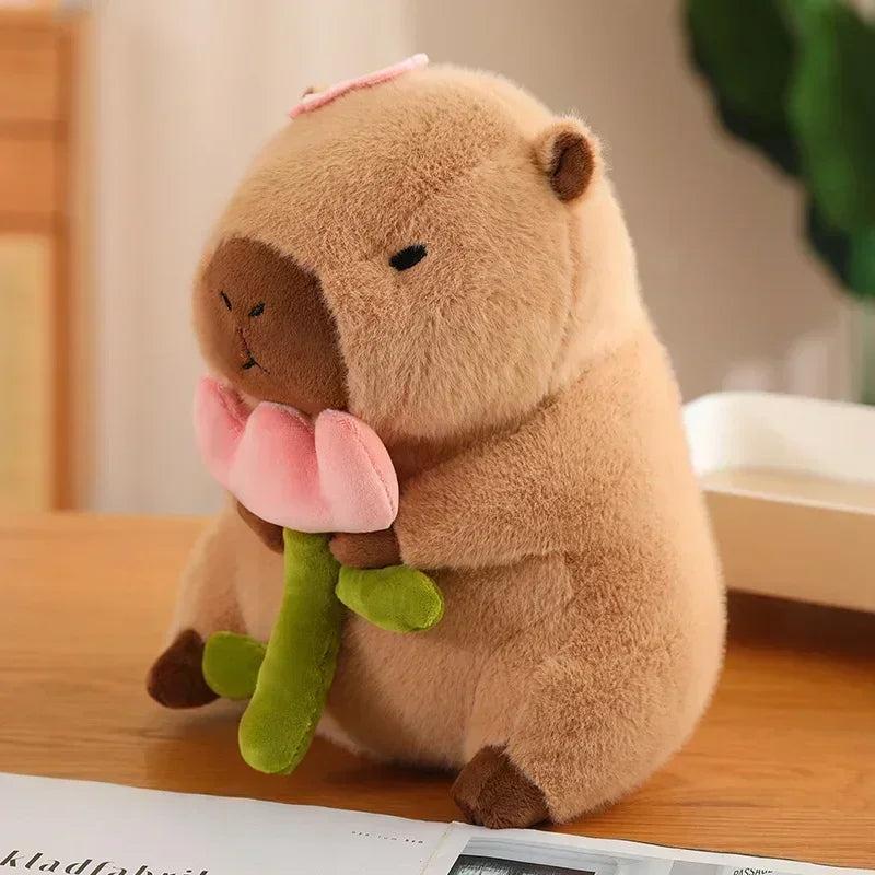 Plush kawaii toy beaver holding a pink flower on a wooden surface