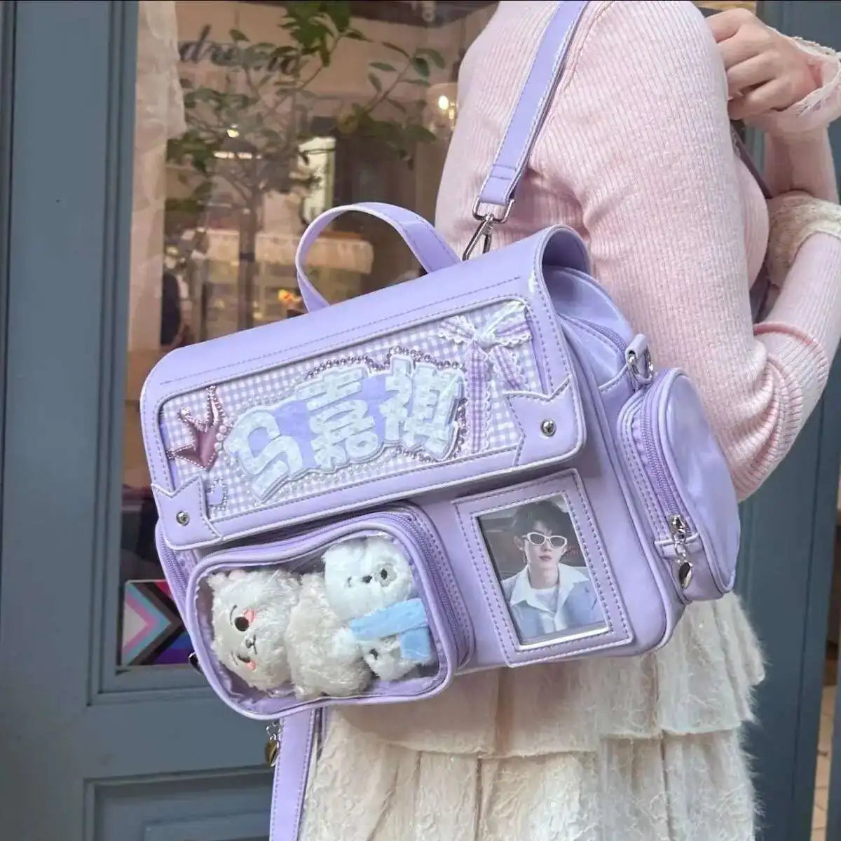 Person holding a purple Kawaii backpack with teddy bears and photos